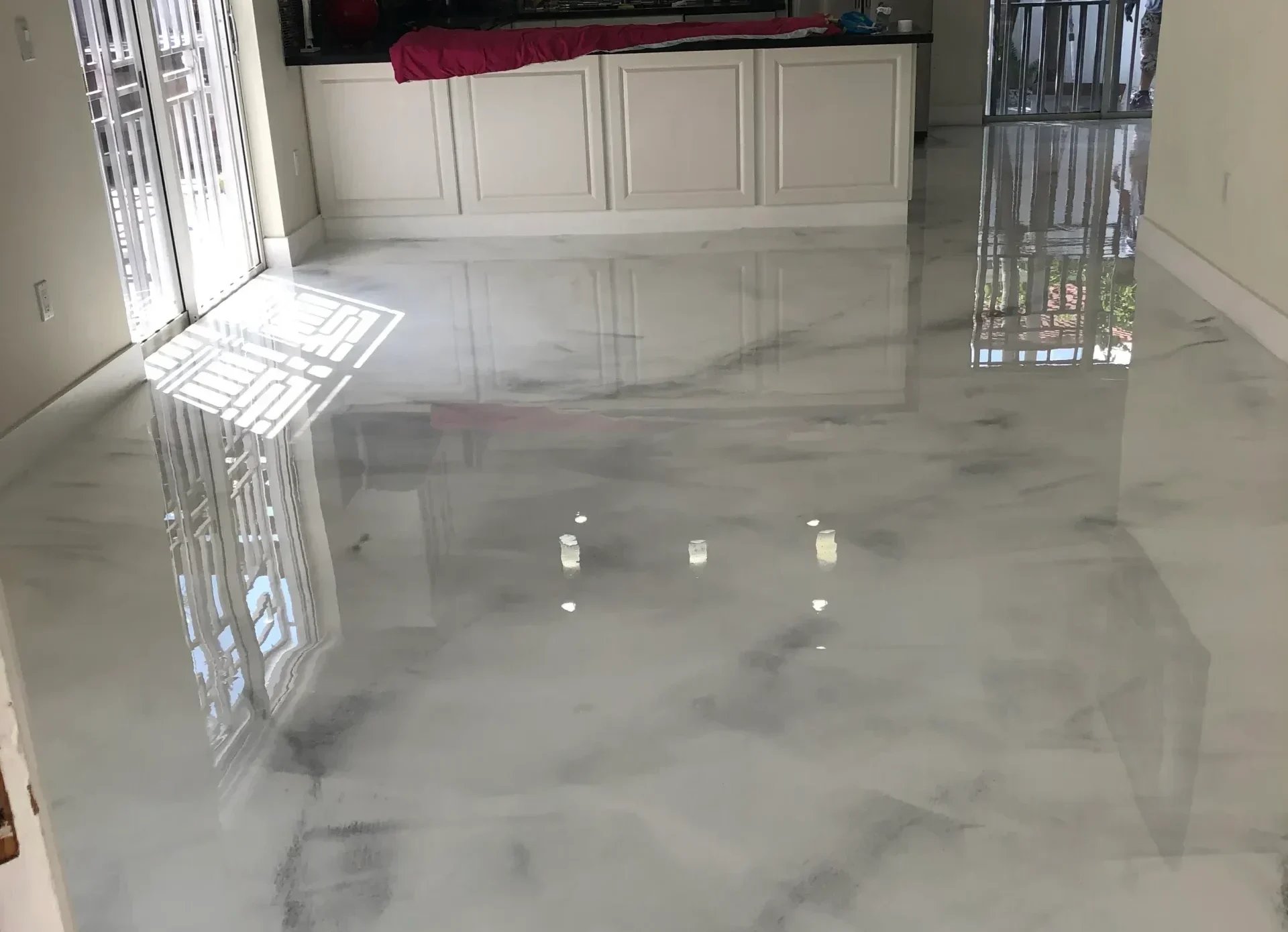 Glossy marble-like epoxy floor with reflective surface and decorative candles
