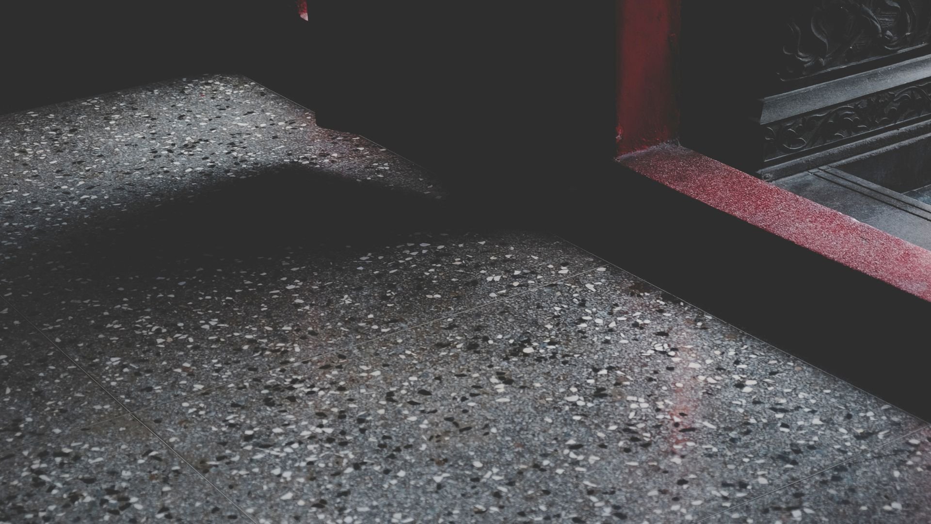 Speckled gray surface with red accent line, dark moody lighting