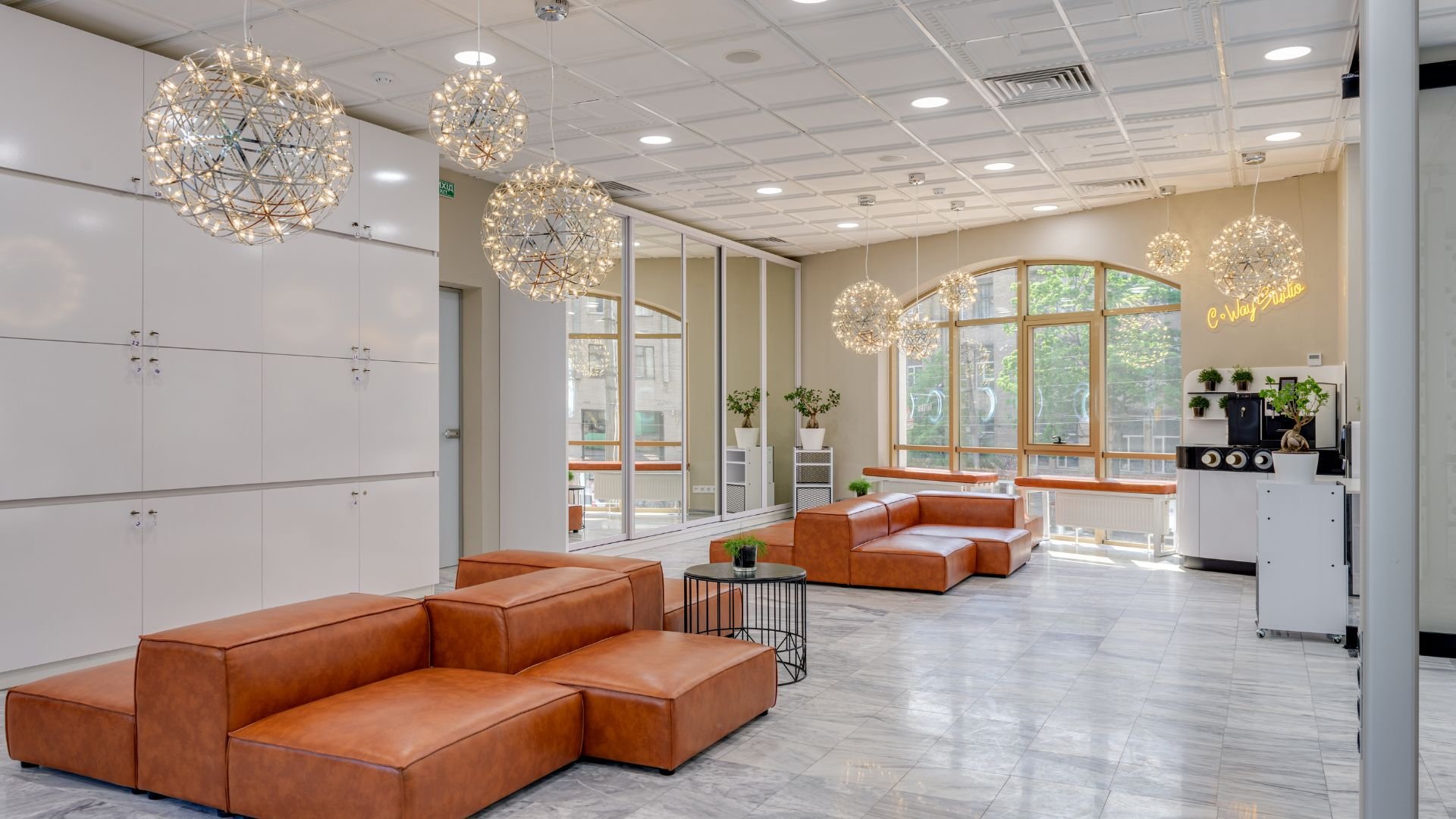 Modern office lobby with leather sofas, sparkling light fixtures, and large windows